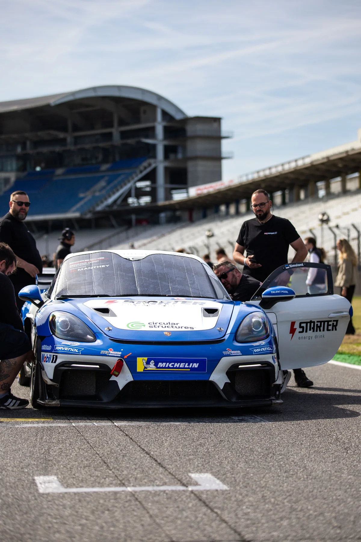 Porsche GT4 and crew in the pit lane